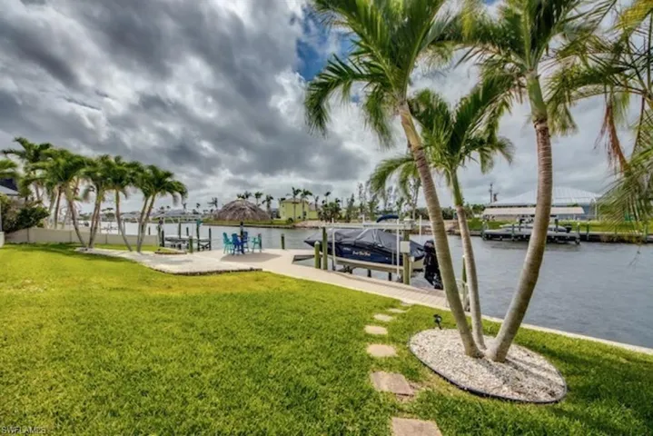 Dock area with a lawn and a water view
