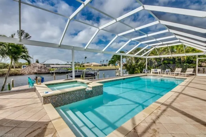 View of pool featuring a patio area, a lanai, and an in ground hot tub