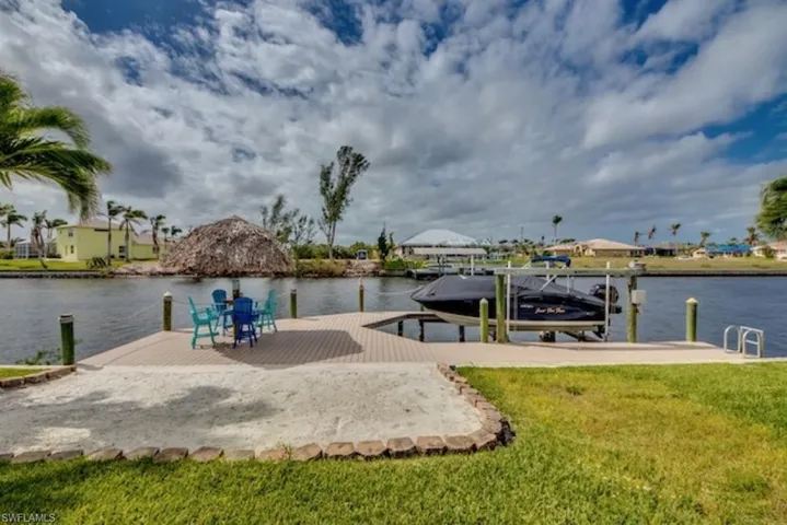 Dock area with a water view and a yard