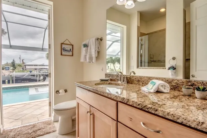 Bathroom with vanity with extensive cabinet space, toilet, and tile floors