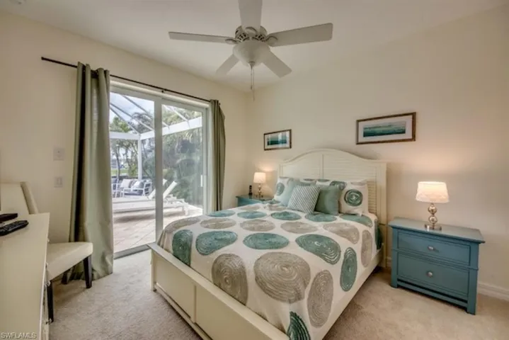 Carpeted bedroom with access to outside and ceiling fan