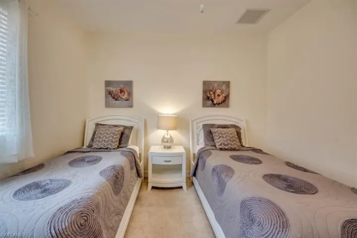 Carpeted bedroom featuring multiple windows