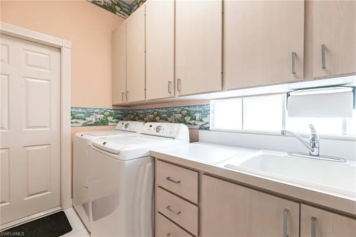 Laundry room with sink and valuable storage space.