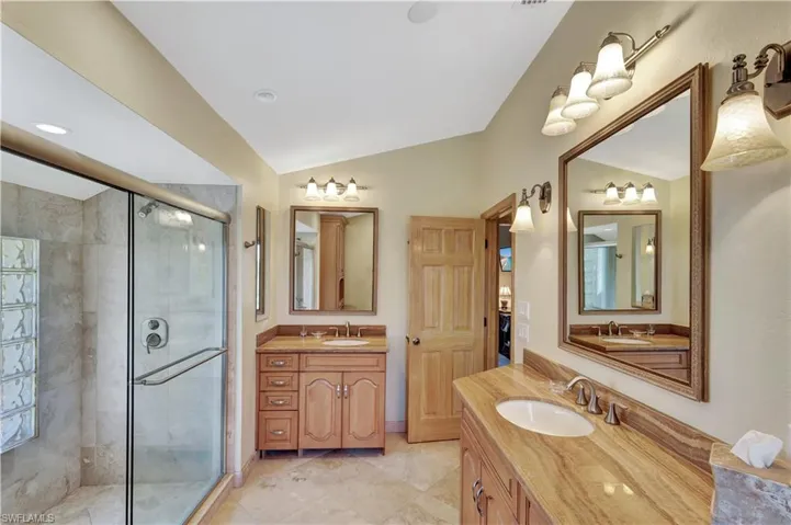 Bathroom with lofted ceiling, vanity, and walk in shower
