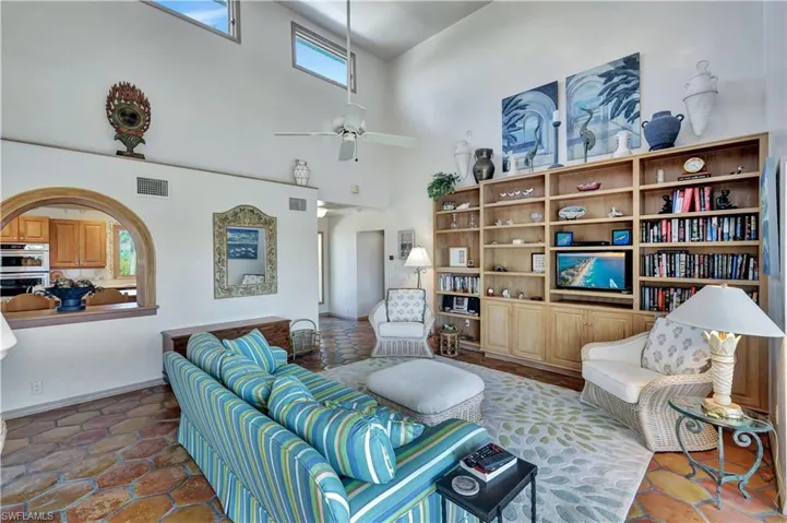 Living room featuring ceiling fan and a high ceiling