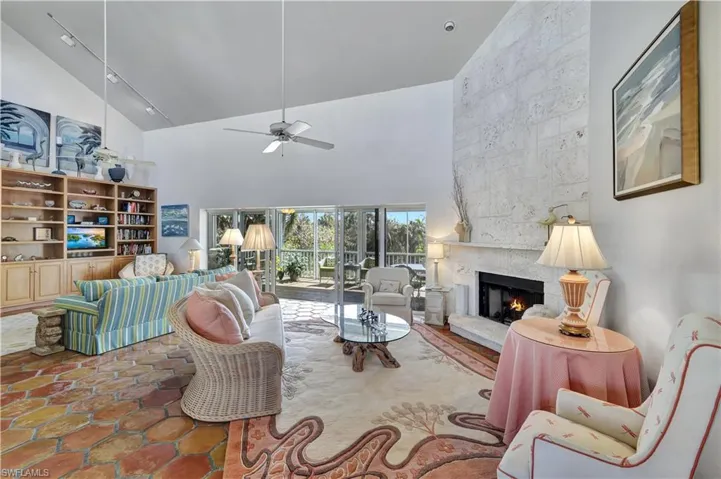 Living room with high vaulted ceiling, a large fireplace, and ceiling fan