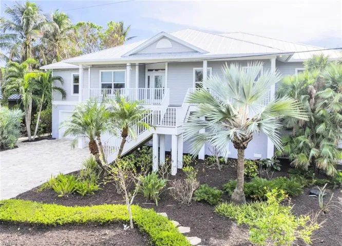 Coastal home featuring covered porch and a garage