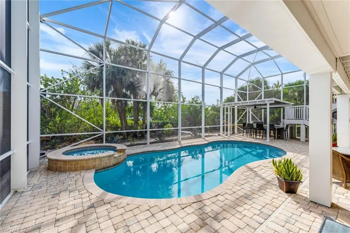 View of pool with a lanai, a patio area, and an in ground hot tub