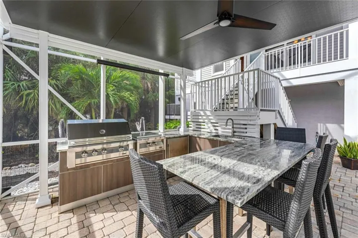 View of patio with a grill, ceiling fan, sink, and area for grilling