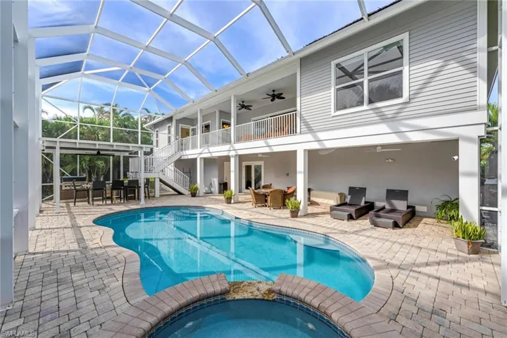 View of pool featuring a patio area, an in ground hot tub, ceiling fan, and glass enclosure