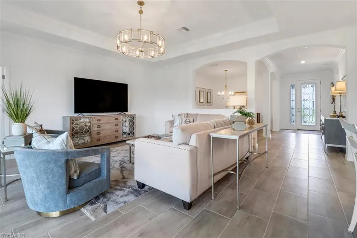 Living room featuring crown molding, tray ceiling, beautifully designed