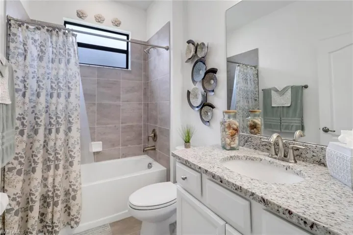 Full bathroom featuring vanity, toilet, and shower / bath combination with curtain