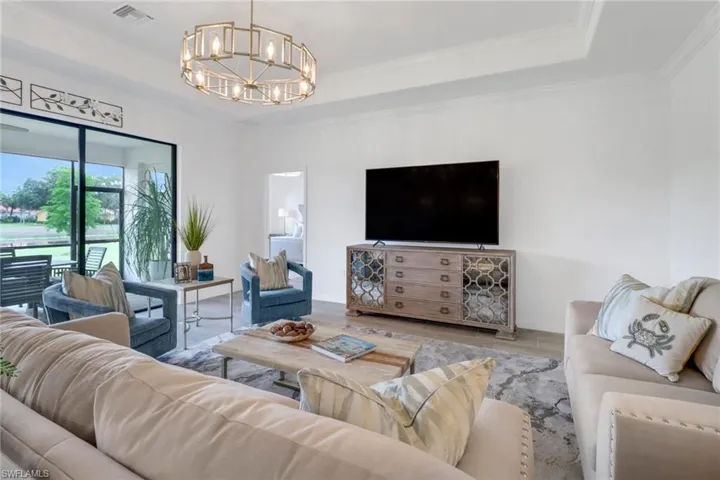 Large  living room beautiful lighting, crown molding, and a raised ceiling