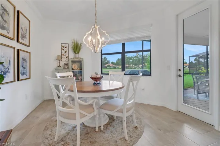 Dining room with ornamental molding and an inviting chandelier, door leads to rear lanai