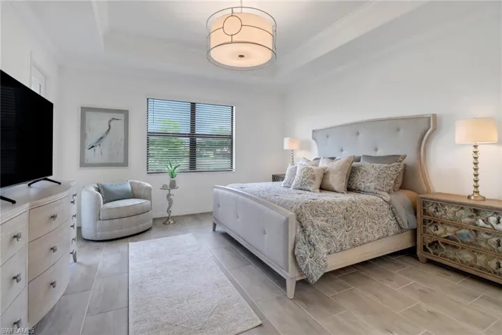 Bedroom featuring a raised ceiling and crown molding