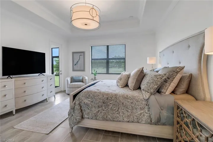 Bedroom featuring access to outside and a tray ceiling