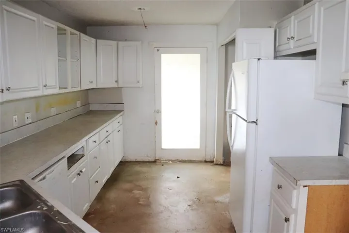 Kitchen featuring white cabinets and white refrigerator