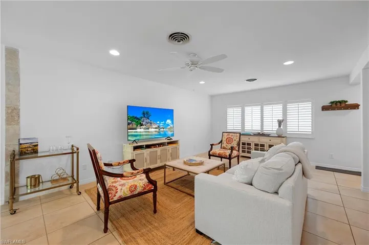 Living area with light tile patterned floors, ceiling fan, and recessed lighting