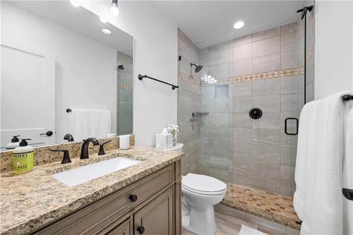 Full bathroom with vanity, a shower stall, and recessed lighting