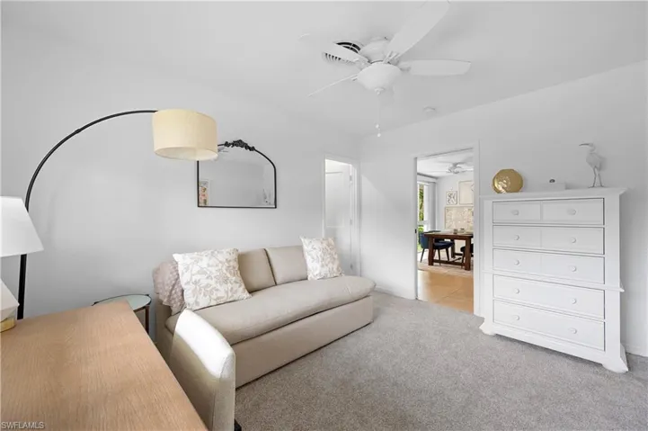 Carpeted living room with ceiling fan