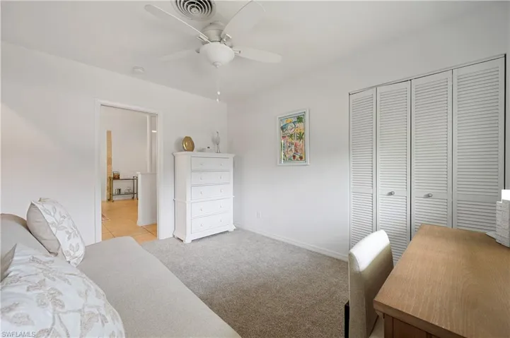 Bedroom featuring light colored carpet, ceiling fan, and a closet