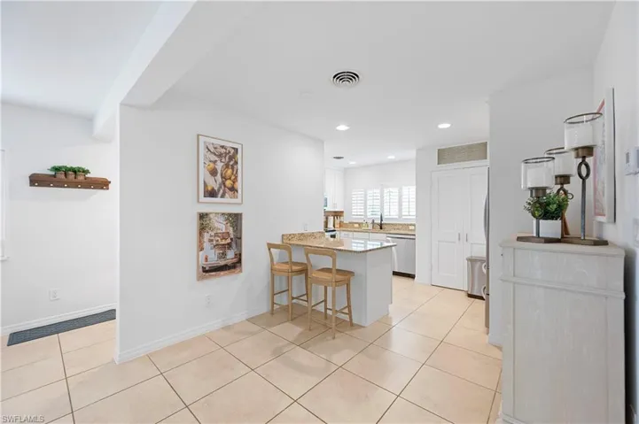 Kitchen featuring a kitchen breakfast bar, a peninsula, light tile patterned flooring, recessed lighting, and stainless steel dishwasher