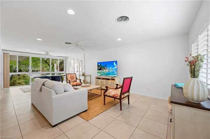 Living area with light tile patterned floors, recessed lighting, and a ceiling fan