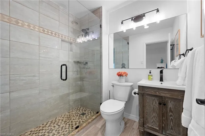 Bathroom featuring vanity, a stall shower, and light wood-style floors