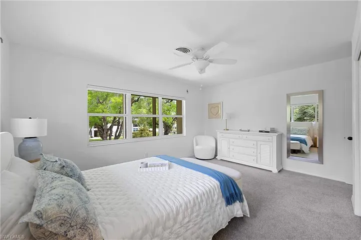 Carpeted bedroom with baseboards and a ceiling fan