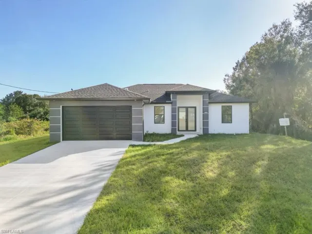 View of front of house with a garage and a front yard