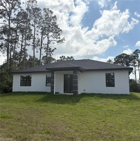 Back of house with a lawn