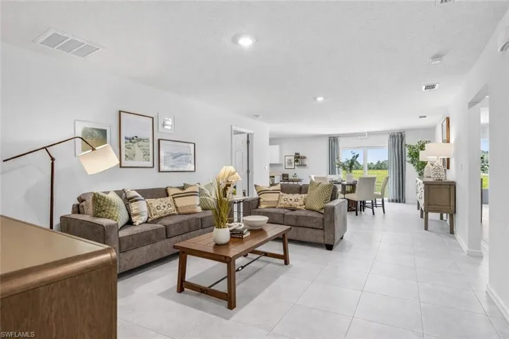 Living room featuring a textured ceiling, light tile patterned flooring, and recessed lighting