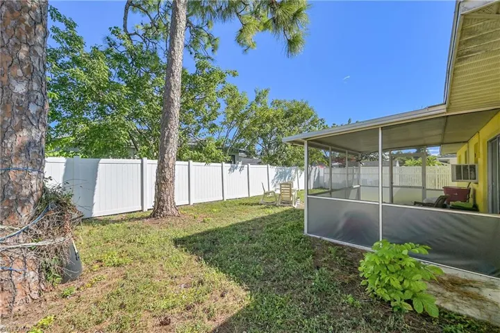 Fenced backyard featuring a sunroom