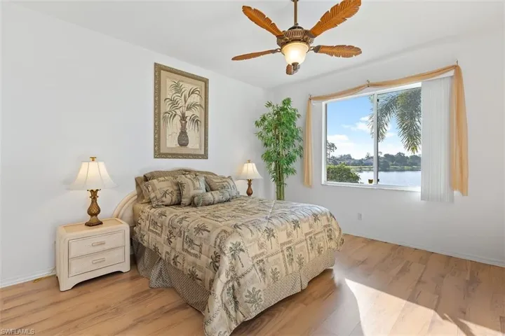 Bedroom with ceiling fan, hardwood / wood-style flooring, and a water view