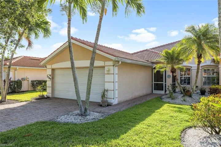 View of side of home featuring a garage and a yard