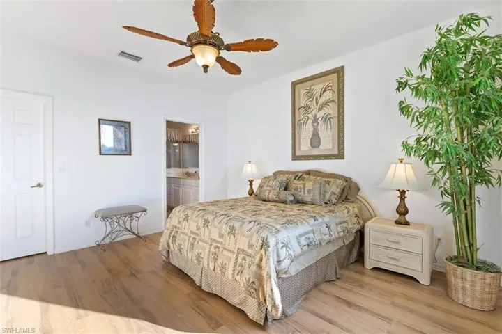 Bedroom featuring ceiling fan, connected bathroom, and light hardwood / wood-style flooring