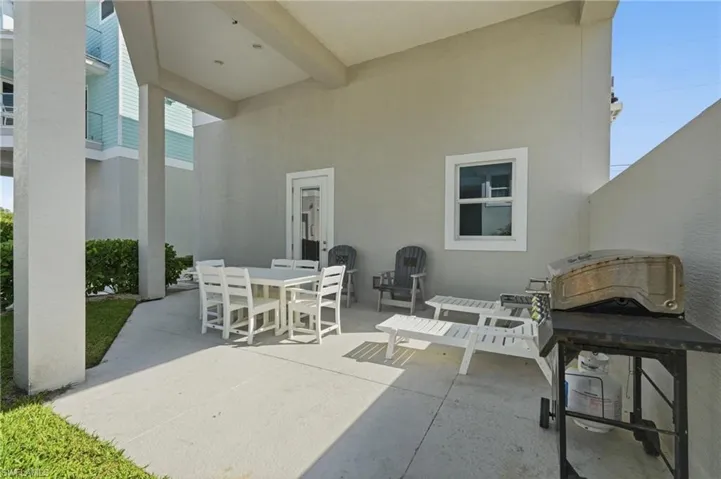 Covered outdoor patio with smooth concrete flooring and a stucco exterior - Virtually Edited Image