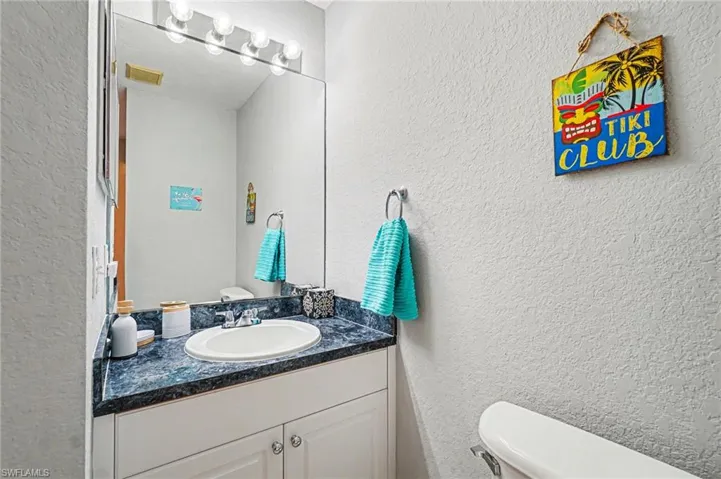 Bathroom vanity featuring a built-in sink, dark mottled countertop, and white cabinetry