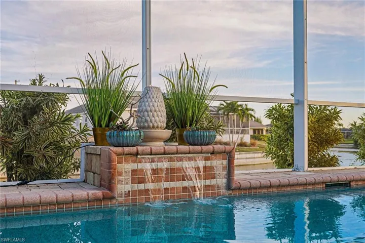 Water feature with brick and mosaic tile detailing, integrated into the pool deck