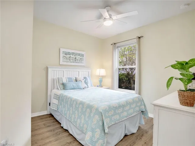 Bedroom featuring baseboards, a ceiling fan, and light wood-style floors