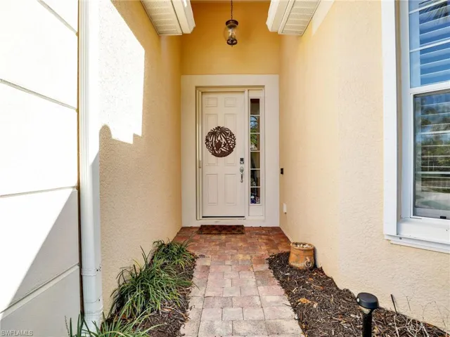 Property entrance featuring visible vents and stucco siding