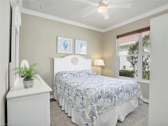 Bedroom with baseboards, visible vents, and ornamental molding
