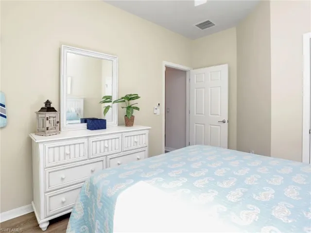 Bedroom featuring wood finished floors, visible vents, and baseboards