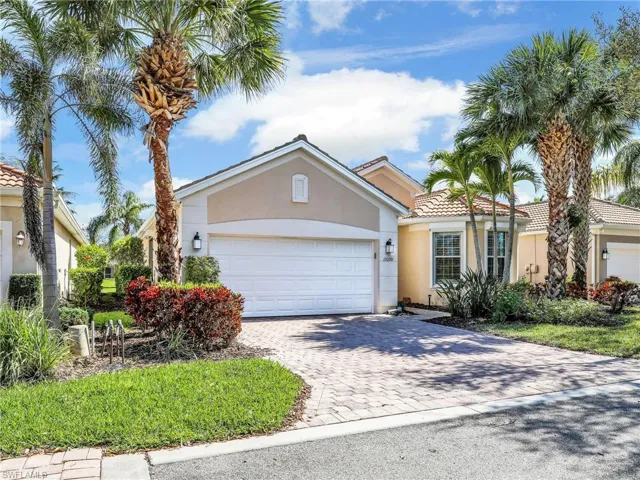 View of front of home featuring a tiled roof, decorative driveway, an attached garage, and stucco siding