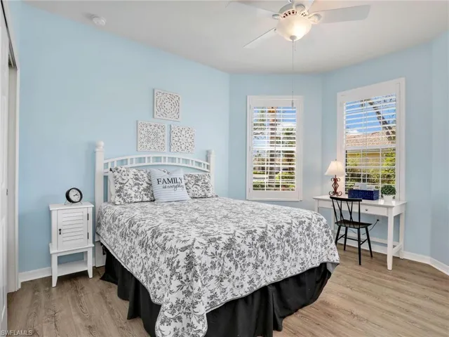 Bedroom featuring ceiling fan, light wood-style flooring, and baseboards