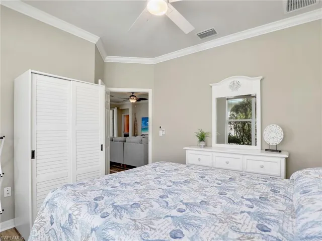 Bedroom with ceiling fan, visible vents, a closet, and ornamental molding