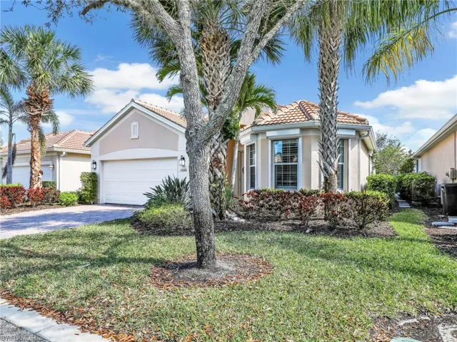 Mediterranean / spanish home with a garage, a tile roof, a front lawn, and stucco siding