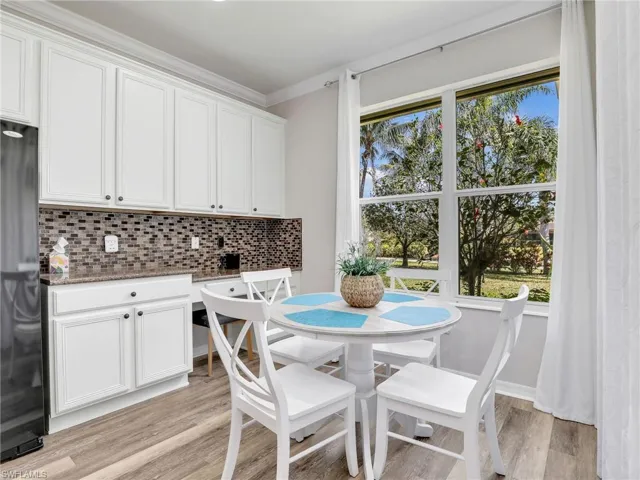 Dining room with light wood finished floors and ornamental molding
