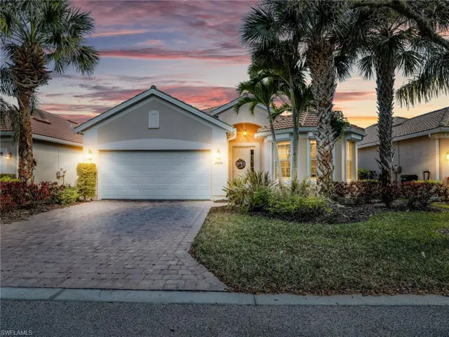 View of front of house featuring decorative driveway, an attached garage, a front yard, and stucco siding