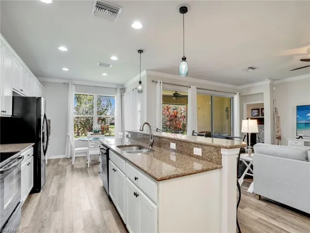 Kitchen with visible vents, electric range oven, dishwashing machine, ornamental molding, and a sink